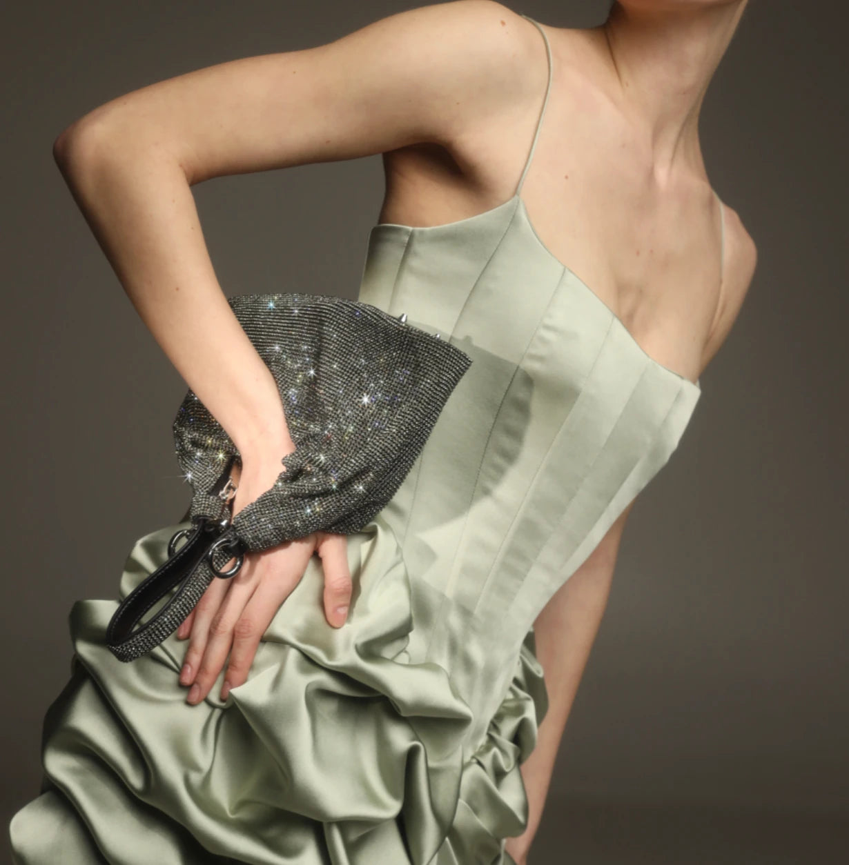 Woman in a light green dress holding a Giarité's Jules Silver crystal-covered bag