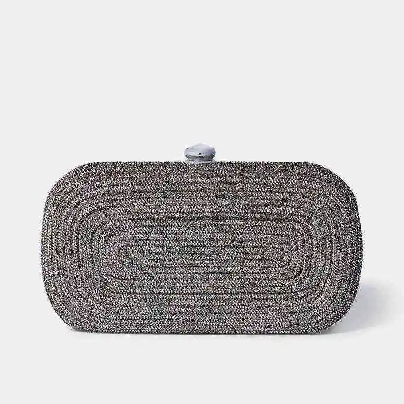 A silver Giarite's LEONIS CLUTCH, featuring a textured, coiled rhinestone design and a top clasp closure