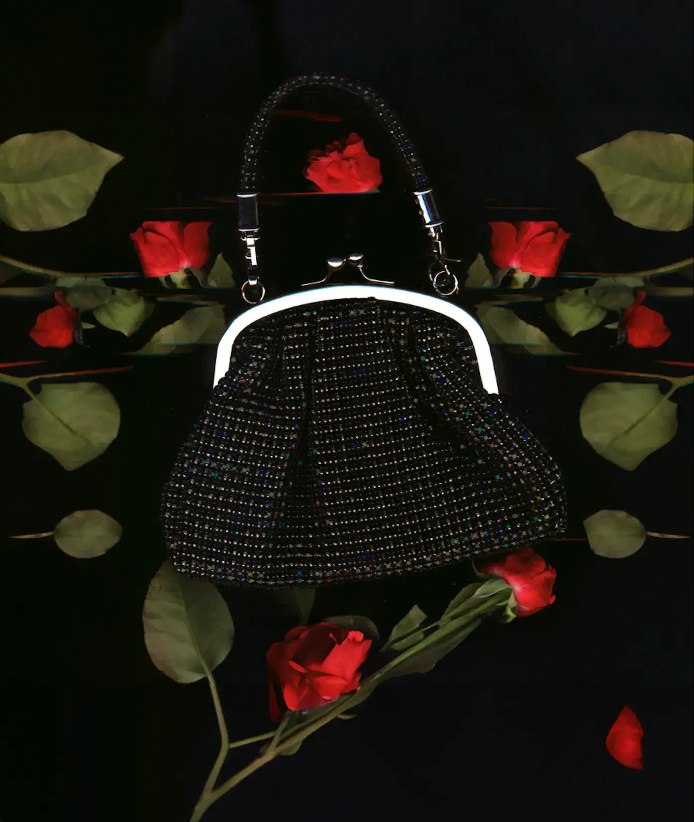 A black Giarité Lima handbag, a vintage-style beaded clutch purse with a silver kiss-lock closure and handle, is centered on a dark background.